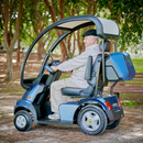 Left Side View Of The AFIKIM Afiscooter S4 Scooter Shown In The Blue Color With The Optional Hard Top Canopy And Rear Lock Box In An Outdoor Setting