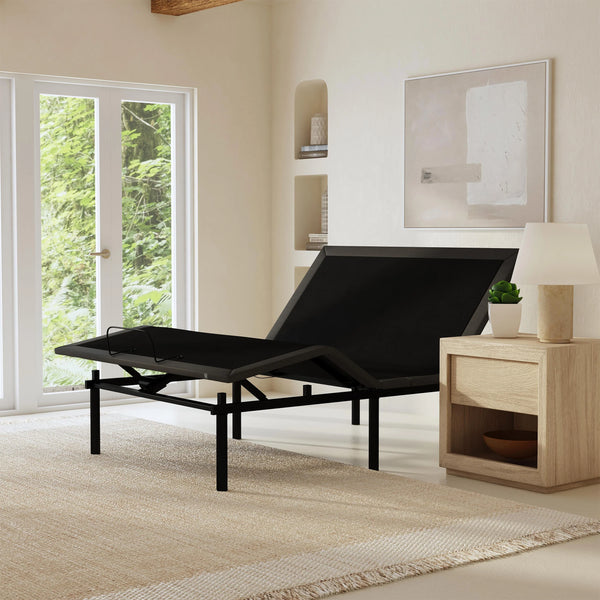 Left Side View Of The Rize Tranquility II Adjustable Bed Shown In The Leg And Head Articulated Position In A Room With A Lamp And Shelves