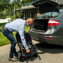 Man Loading The Feather Mobility Scooter Into The Trunk Of A Car 