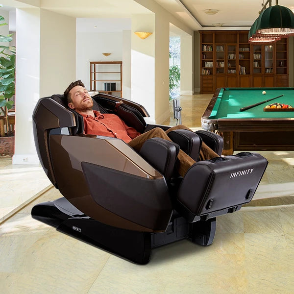 Man Relaxing In The Infinity Imperial Syner-D Massage Chair In Dark Brown /Dark Brown Color In A Living Room With A Pool Table