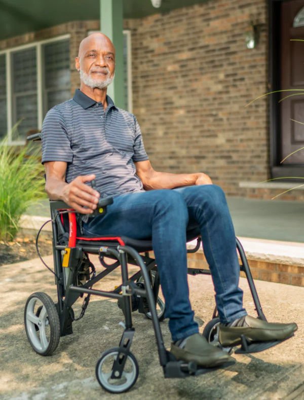 Man Sitting In The Feather Electric Wheelchair Outdoors On A Patio