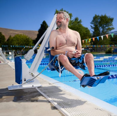 Man Using The Aqua Creek Ranger 2 Pool Lift To Get Into A Swimming Pool On A Sunny Day.