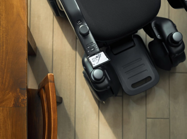 Overhead View Of The STRUTT ev1 Smart Electric Mobility Vehicle Shown Next To A Table In An Indoor Setting