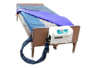 Rear View Of The Proactive Medical Protekt Aire 9900 Low Air Loss/Alternating Mattress System With Cover Removed On A Brown Metal Frame, With The Control Unit Attached To The Footboard