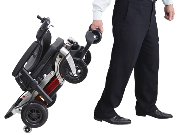 Right Side View Of The FreeRiderUSA Luggie Travel Power Wheelchair Shown In The Folded Position With A Man In Dress Clothes Rolling The Chair