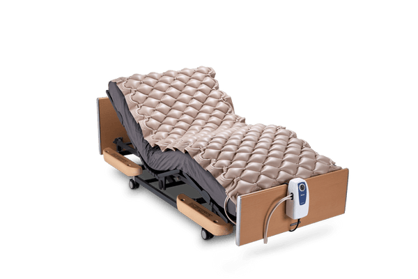 Right Side View Of The Wellell Domus 1 Alternating Pressure Redistribution Mattress Shown On An Adjustable Bed With The Control Unit Hanging Off The Footboard