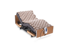 Right Side View Of The Wellell Domus 1 Alternating Pressure Redistribution Mattress Shown On An Adjustable Bed With The Control Unit Hanging Off The Footboard