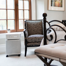 Room Interior With A Leopard Print Chair, White Ottoman, And The Austin Air Systems Bedroom Machine Air Purifier Shown In The Sandstone Color Next To The Window