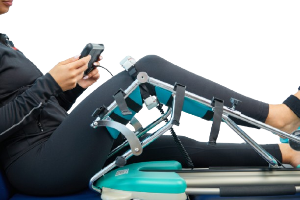 Side View Of A Woman Using The Kinetec Spectra Kompanion Knee CPM Machine With Tablet