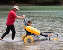 Side View Of The AccessRec WaterWheels Floating Beach Wheelchair Shown With Man Pushing Chair With Young Girl Sitting On Chair In A Lake Setting