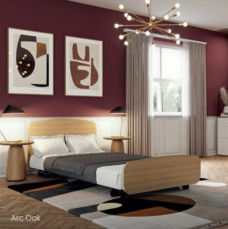 Side View Of The Accora Empresa 12-Function Hi Low Adjusting Nursing Bed Shown In Arc Design With Oak Wood Finish In A Homecare Setting