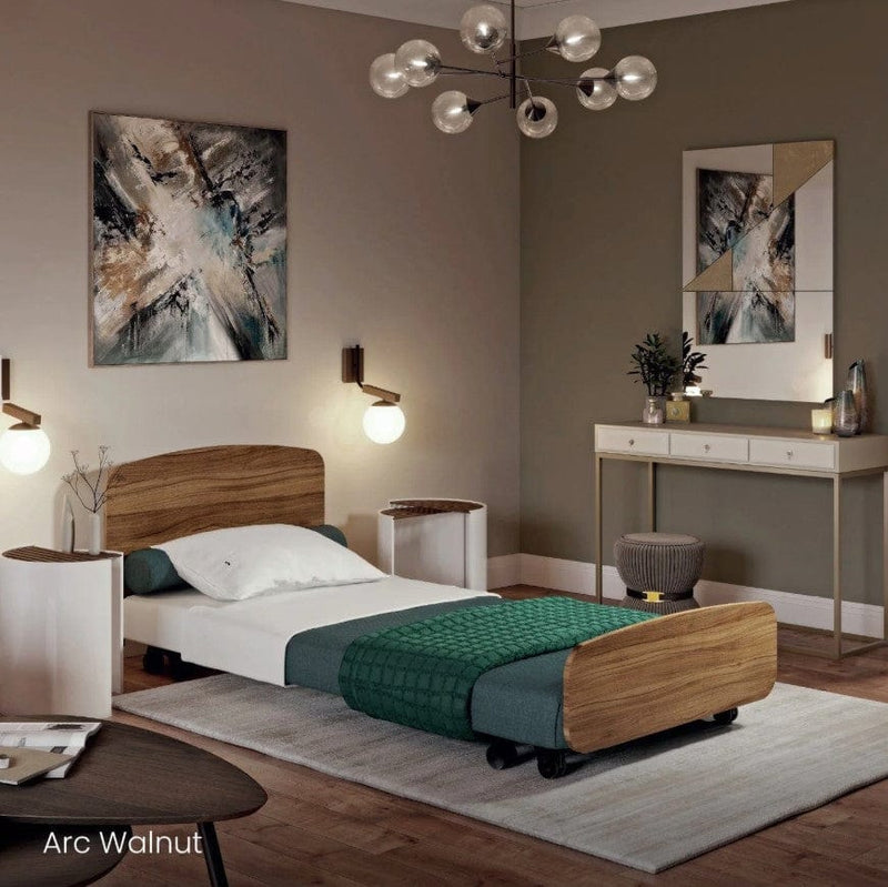 Side View Of The Accora Empresa 12-Function Hi Low Adjusting Nursing Bed Shown In Arc Design With Walnut Wood Finish In A Homecare Setting