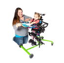 Side View Of The EasyStand Bantam Small Standing Frame Shown In Green Color With Child In Stander And Woman Kneeling Next To Her