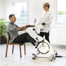 Side View Of The Kinetec Kinevia Duo Active Passive Trainer Man Sitting Operating The Machine With Doctor Standing Explaining The Functions