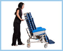 Side View Of The Med Mizer FlexTilt Comfort Chair Shown With Caregiver Holding The Handles