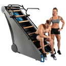 Side View Of The StairMaster Jacob's Ladder X Stair Climber Shown With A Woman Standing And A Man Sitting On The Climber