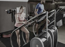 Side View Of The StairMaster Stairway GTL Stair Climber Shown With A Woman Operating The Climber And A Man Operating Another In A Gym Setting