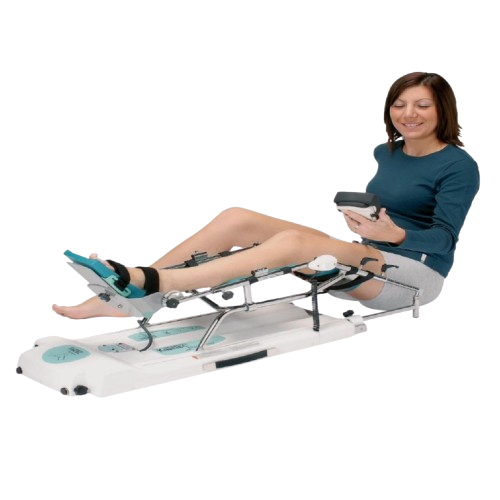 Side View Of Woman Using The Kinetec Spectra Knee CPM Machine With The Remote Control.