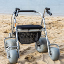 Wheeleez All-Terrain Beach Rollator Rear View With Polyurethane Wheels, Foam Handles, And A Mesh Storage Compartment, Displayed On A Sandy Beach.