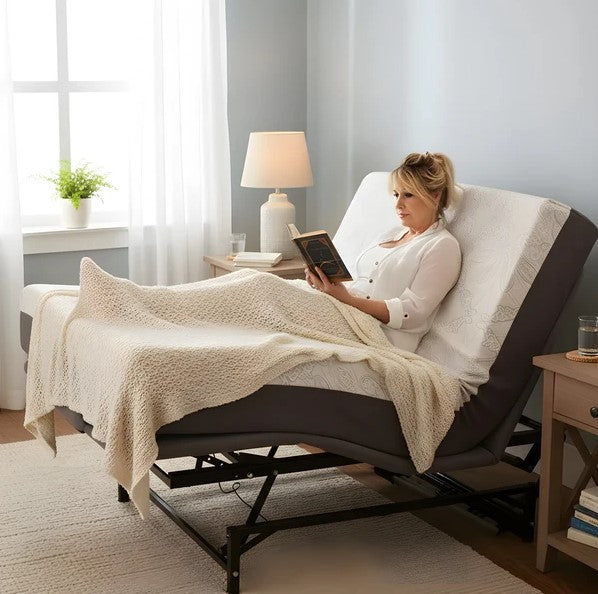 Woman Reading A Book In A Book While Sitting Up In The Flexabed Hi Low Adjustable Bed With A Blanked Draped Over Her, In A Well-Lit Room