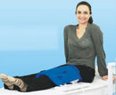 Woman Using The Almagia International ALMAG-2 PEMF Therapy Device On A Medical Table With a Blue Background 