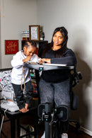 Woman Using The EasyStand Evolv Large Shown With Child Standing Next To Her In A Home Setting