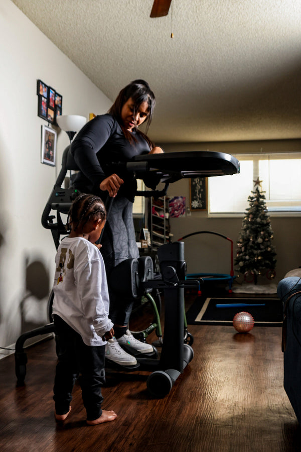 Woman Using The EasyStand Evolv Large Shown With Child Standing Next To Her In A Home Setting