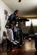 Woman Using The EasyStand Evolv Large Shown With Child Standing Next To Her In A Home Setting