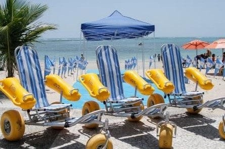 Front View Of The AccessRec WaterWheels Floating Beach Wheelchair Shown With Three Wheelchairs On A Sunny Day At The Beach