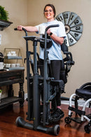 Front View Of The EasyStand Glider Large Active Standing Frame Shown With Smiling Woman Using The Device In A Home Setting