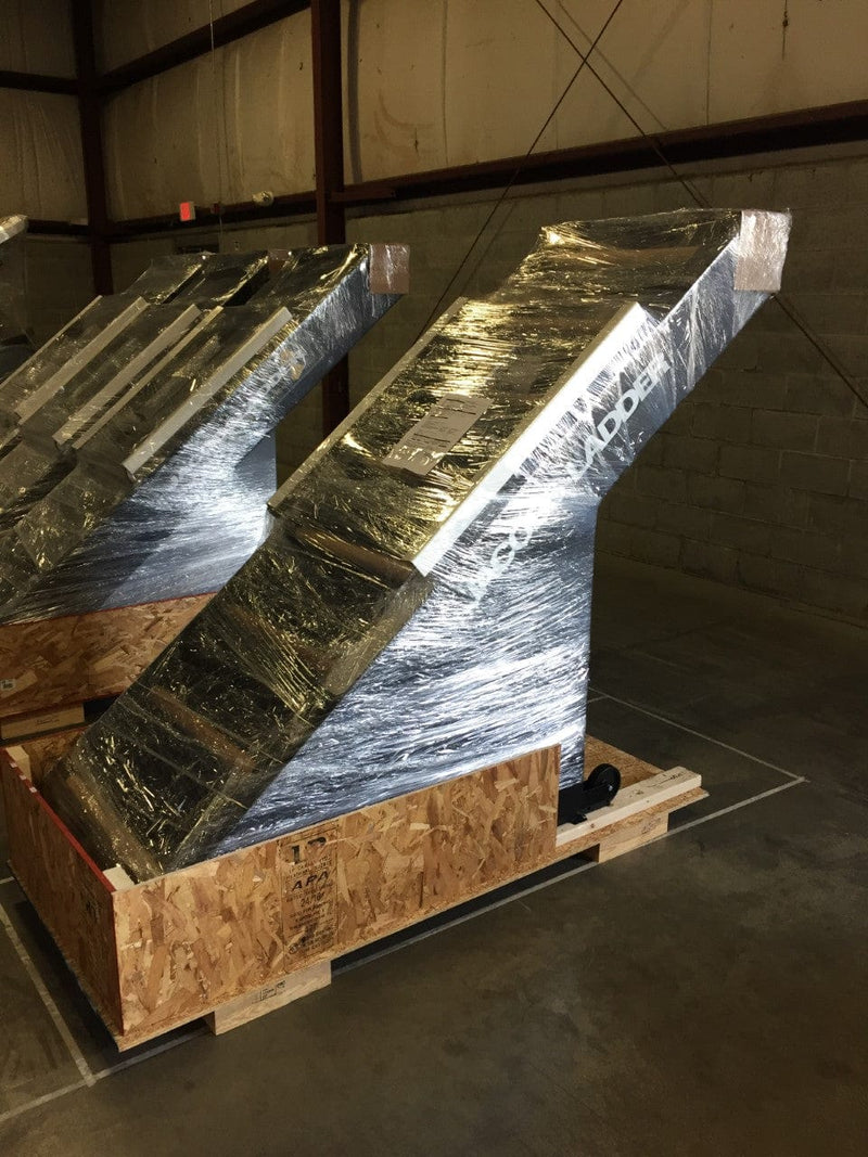 Rear View Of The StairMaster Jacob's Ladder 2 Stair Climber Shown With Multiple Models In A Warehouse Setting