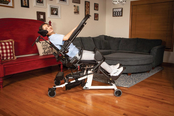 Side View Of The EasyStand Bantam Medium Standing Frame Shown With Girl Using Device In A Chair Position