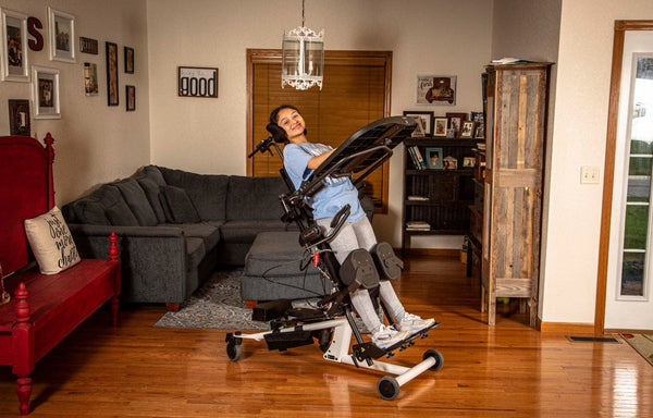 Side View Of The EasyStand Bantam Medium Standing Frame Shown With Girl Using Device In The Supine Position In A Home Setting