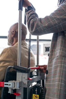 Woman Extending The Handlebar Of The Atlas Stair Climbing Wheelchair Lift